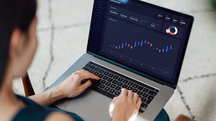 A woman is viewing the graph displayed on the laptop.