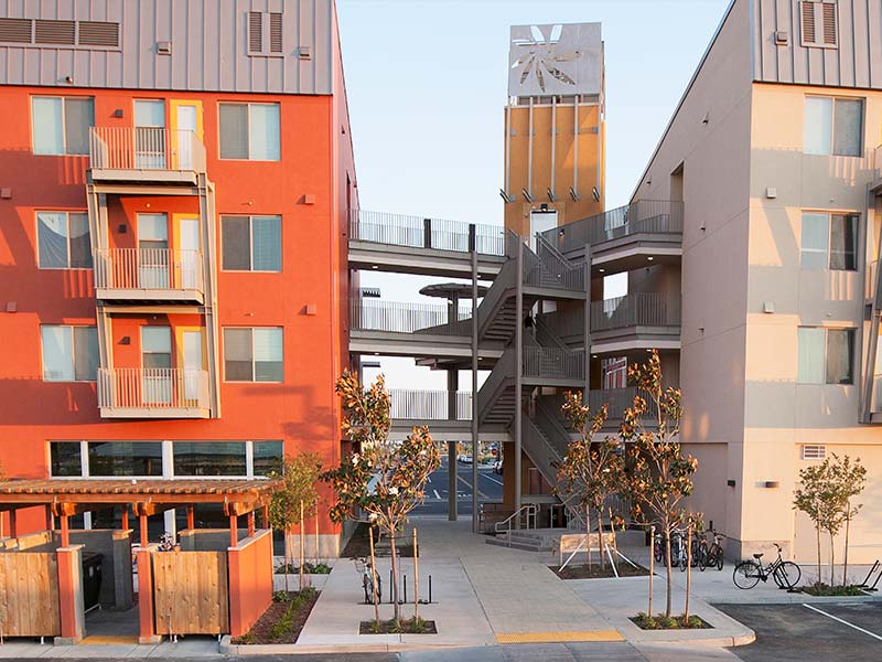 A corner view of an apartment building, strategically located at the intersection of two streets