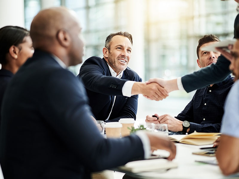 Shot of businesspeople shaking hands during a meeting in an office