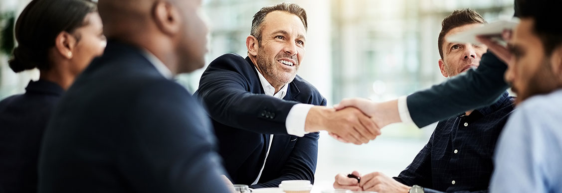 Shot of businesspeople shaking hands during a meeting in an office